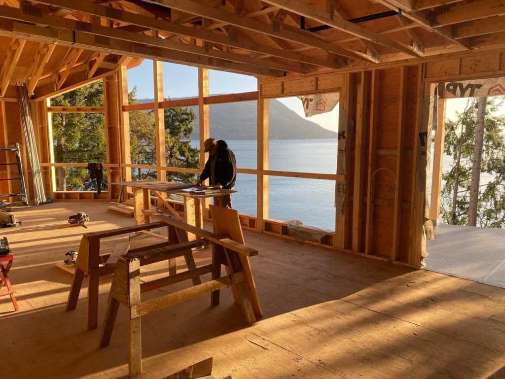 K2 crew member standing in framed home with beautiful Maple Bay views in behind